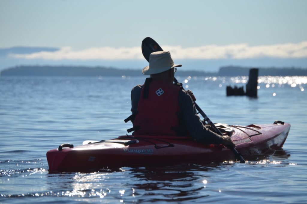 William Vanderwees, a participant in the RAP Tour of the Lower Kaministquia River moves out onto the glass calm waters of Lake Superior near Mission Island Marsh. The Welcome Islands and Sleeping Giant (partially obscured by fog) are in the background.
